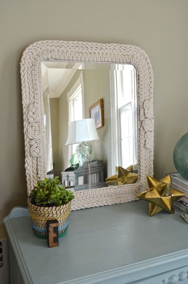 Knotted rope mirror displayed in room.
