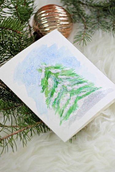 Paint a simple snowy pine with watercolors