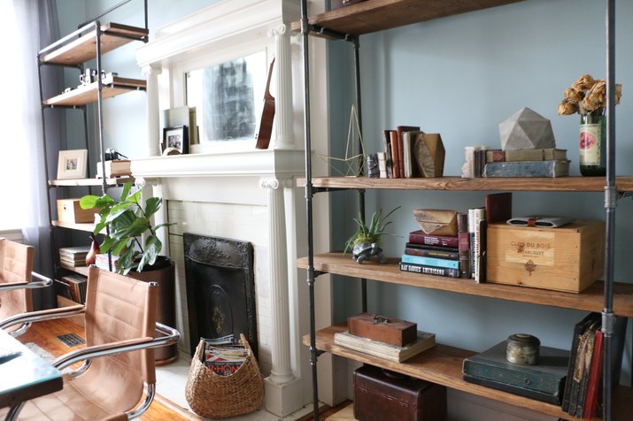 matching industrial pipe bookcases flanking a fireplace