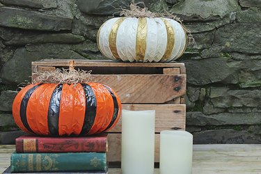 dryer vent pumpkins displayed on a wooden crate