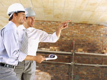 two male architects discussing work at a construction site