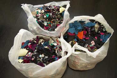 Three grocery bags of fabric scraps.